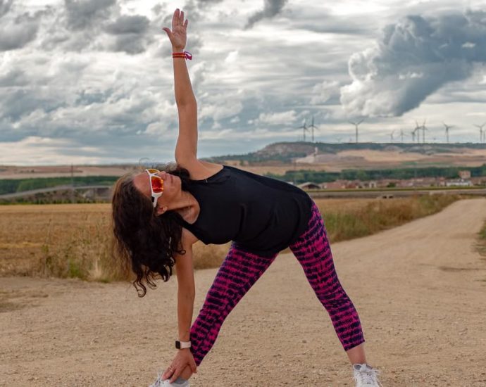 Outdoor fitness scene of a woman stretching on a dirt path in Soto de Cerrato amidst scenic landscapes.